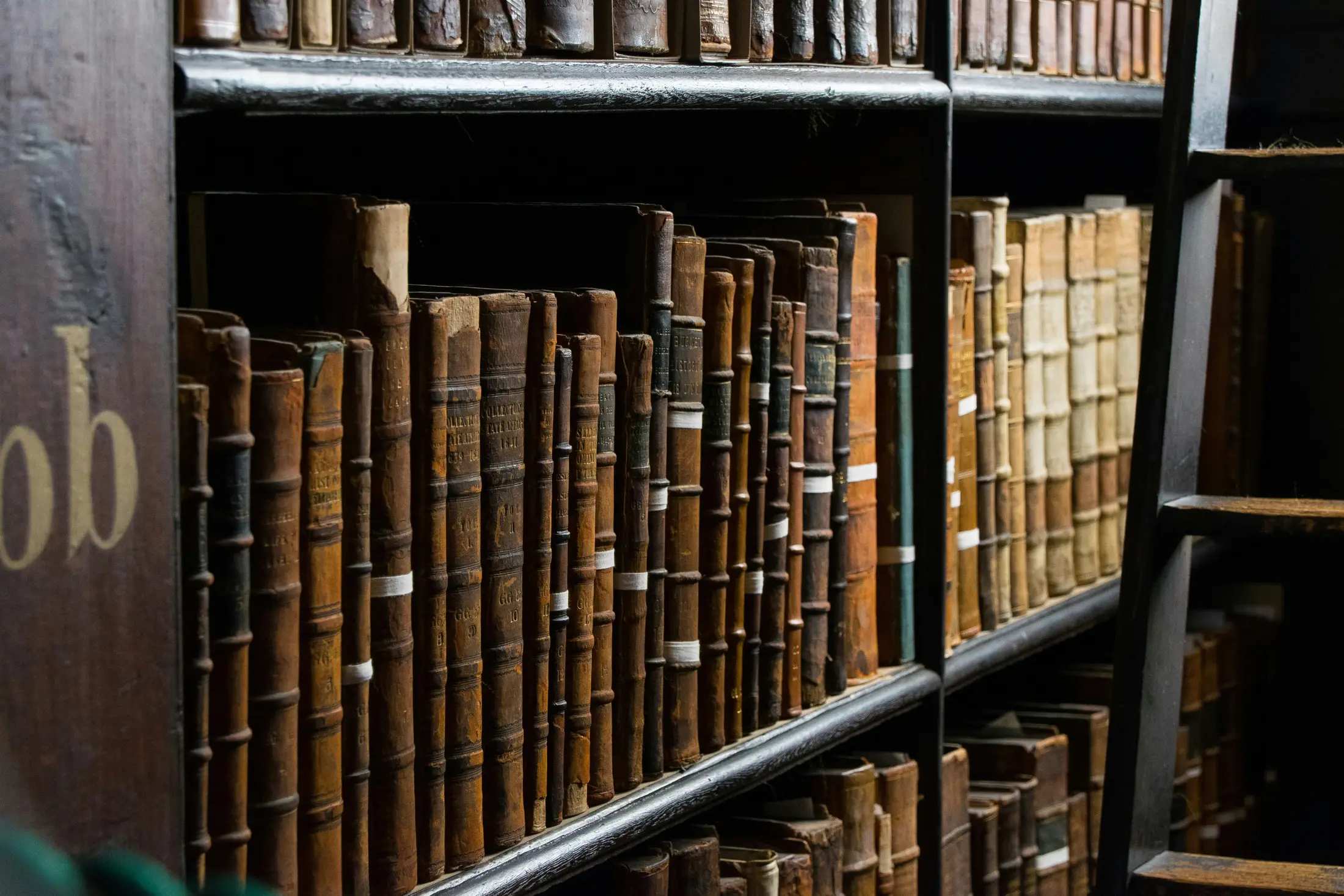 Estantes escuras de uma biblioteca jurídica com volumes antigos encadernados em couro