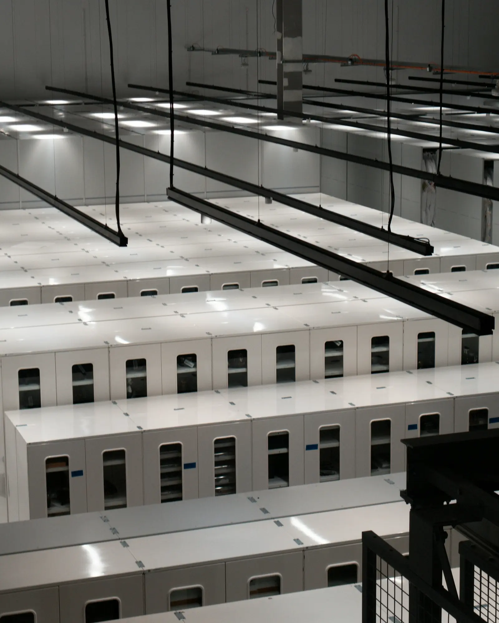 Corredor de um data center com fileiras de gabinetes de servidores brancos