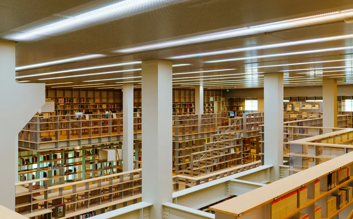 Acervo de biblioteca com fileiras de estantes e colunas