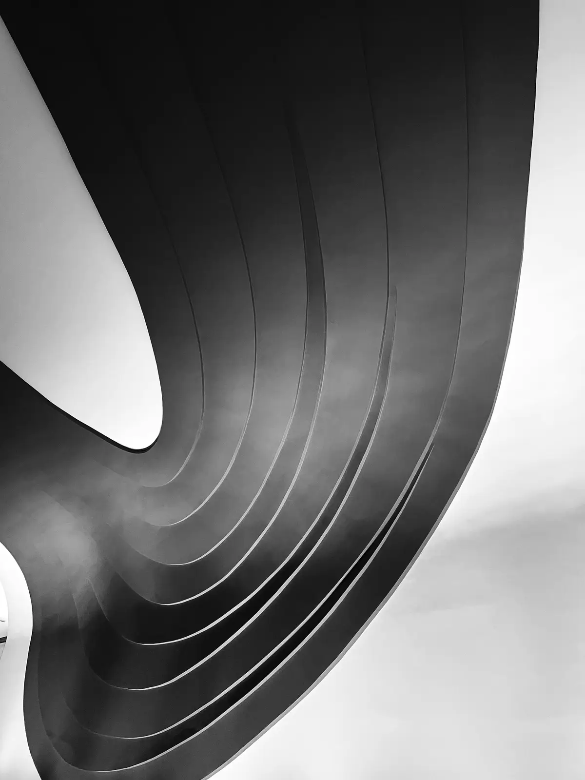 Escada em espiral de concreto, em preto e branco